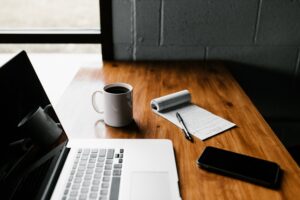 8 Reasons Why Your Small Business needs a Website - Computer, Coffee, Notepad and phone on a desk